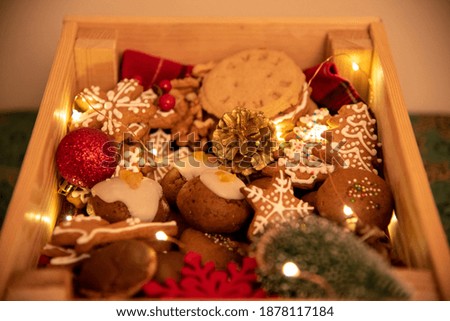 Basket full of cookies with a wooden angel on green background. Christmas decoration with cookies and fairy lights. Box full of cookies. 