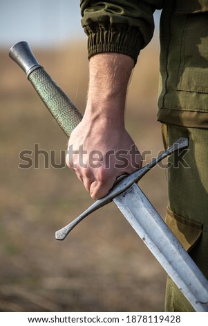 close-up photo of a hand with a sword Royalty-Free Stock Photo #1878119428