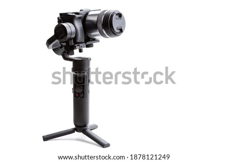 Gimbal three-axis motorized stabilizer with mounted mirrorless camera isolated on white background  Royalty-Free Stock Photo #1878121249