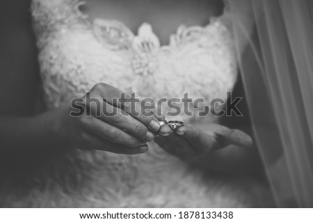 The bride holds the wedding rings on her hand