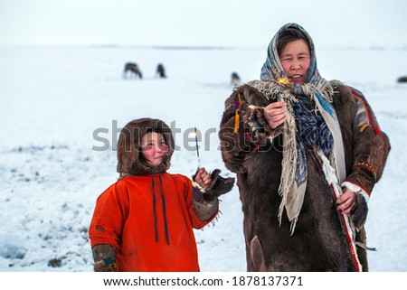 A resident of the tundra, indigenous residents of the Far North, Girl holding a sparkler, The woman holds a sparkler for the first time in her life, looks with surprise with her daughter