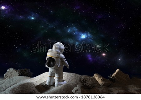 Astronaut in a space suit looking at milky way galaxy. Space travel concept. 