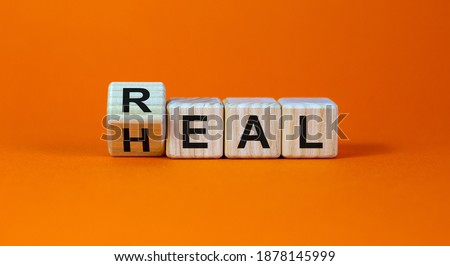 Real heal symbol. Fliped a wooden cube with words 'Real heal'. Beautiful orange background, copy space. Medical and real heal concept. Royalty-Free Stock Photo #1878145999