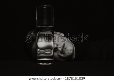 black and white surreal portrait of a man through the glass of a can of water Royalty-Free Stock Photo #1878151039