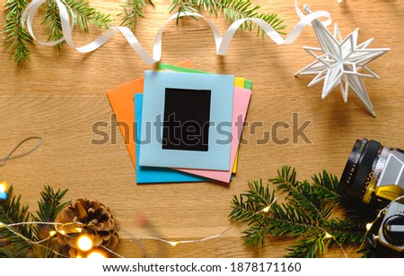 Christmas patter for postcard with pine, craft paper, camera, handmade christmas cards. top view on wooden desk. Colors Photo frames. Stack of frames. Retro image. Foto 