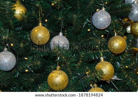 Close-up of a Christmas tree with gold and white shiny balls. Christmas background.