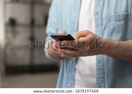 Virtual communication. Male hands holding new smartphone model touching sensor screen to browse internet. Close up of man viewing website social network connecting with shop bank chatting using cell Royalty-Free Stock Photo #1878197608
