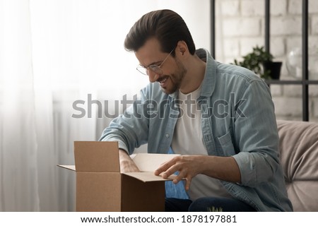 That is just what. I expected Happy young man unboxing small package sending receiving postal dispatch. Loyal satisfied client customer of courier service get consumer goods from online marketplace Royalty-Free Stock Photo #1878197881