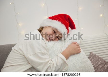 Girl in Santa Claus hat on sofa