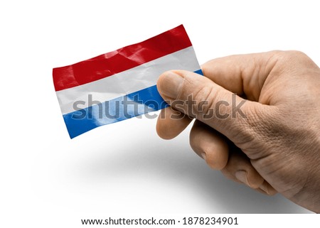Hand holding a card with a national flag the Netherlands