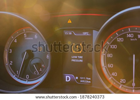 Low tire pressure error sign. Warning lights flash on the car dashboard. 