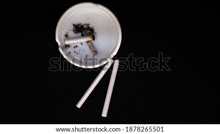 Сigarettes and cigarette butts in an ashtray,on a black background,close-up.