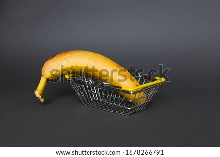 grocery cart with banana for market on gray background. minimal creative food concept