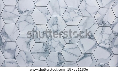 Hexagon marble or granite tiles newly installed on the kitchen backsplash, modern design of gray and white porcelain flooring tiles and it can be install on shower walls or floors. Showroom detail.