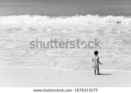Black and white picture of little girl on shore.