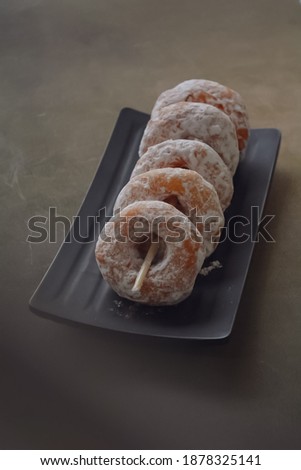 Selective focus of Donuts greased with icing sugar. Blurry foreground and background.
