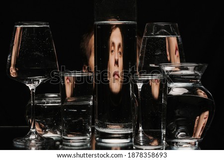 strange abstract portrait of a man through the glass of the tank with water with the reflections and distortions