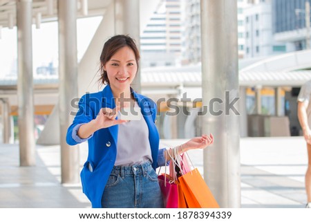 Beautiful girls with shopping bags are smiling while doing shopping in the mall