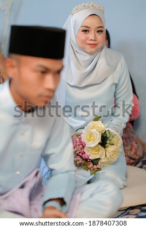 Bride and groom wearing baby blue Malay traditional cloth pose during wedding celebration in Malaysia