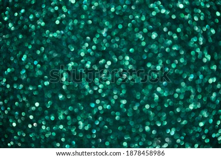 Green abstract background with bokeh. Sparkling glitter texture. Holiday decorations.