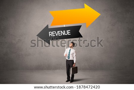 Young business person in casual holding road sign with REVENUE inscription, business direction concept