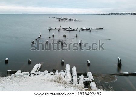 Winter minimalistic landscape with an old ruined pier in the Arctic. Long exposure.