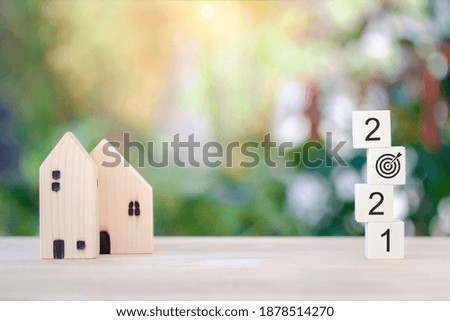Wooden block and one target for new house in 2021 NEW YEAR concept, hope, plan for stock market, property, business isolated on bokeh background.