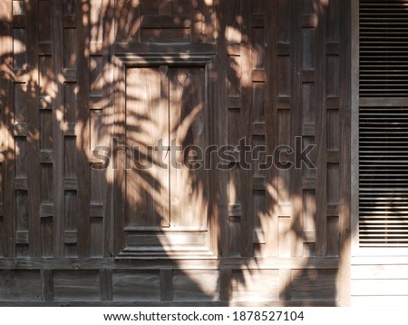 Detailed wood wall and window of ancient Thai house.
