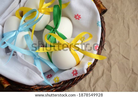 Easter eggs with colorful satin ribbon bows. Spring holiday. Easter photo background. Easter holiday eggs in basket.