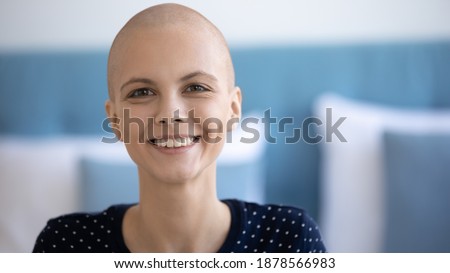Headshot portrait of bald headed young woman struggle with cancer at home or in hospital room. Smiling female having oncology disease look at camera motivated to survive enjoy future life. Copy space