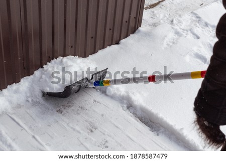 City service cleaning snow in winter with a shovel after a snowy yard.
