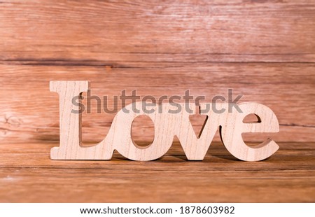 Wooden letters forming word LOVE written on wooden background
