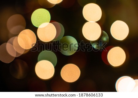 Abstract bokeh light background. Beautiful bokeh lights glowing on dark background. Festive background for Christmas holiday celebration or New-Year party. Blurred circles of light.