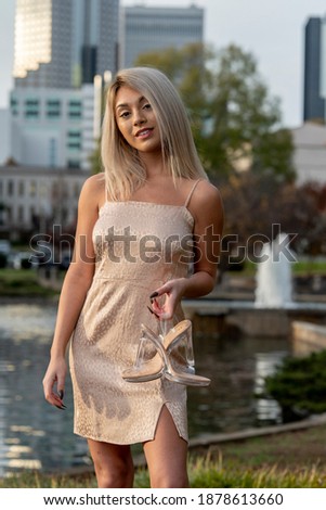 A gorgeous young blonde model poses outdoors while enjoying an autumn day