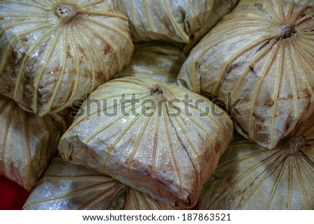 Rice wrapped in lotus leaves, large and overlapping. 