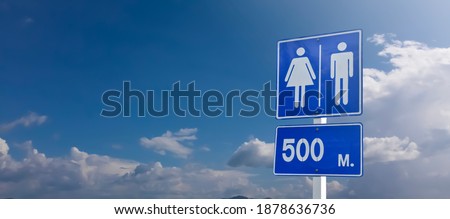 Traffic sign: toilet in 500 meters ahead sign on pole with clouds and bluesky background.