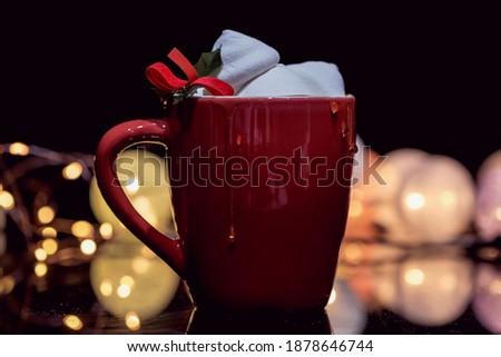Whte marshmallows in a large red mug on a black background with bokeh effects, close up, macro photography