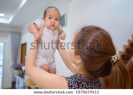 Portrait of Asian young woman with newborn baby in house