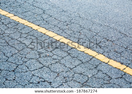 Yellow line on asphalt road crack surface