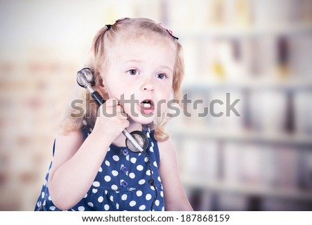 curly-haired little girl with a vintage telephone