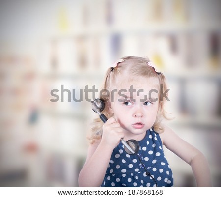 curly-haired little girl with a vintage telephone