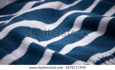 Light and dark blue stripes on white wool garment