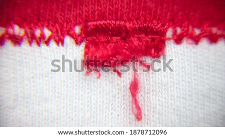 Torn red label on red stitched border
