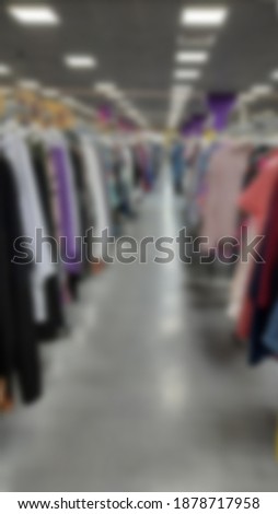 Blurred background of racks with clothes inside the store. A supermarket, fashionable clothing. The sale of goods to customers.
