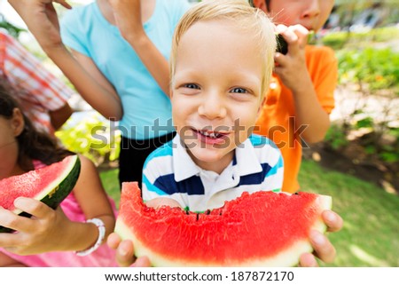 Boy eating watermelon and looking at the camera