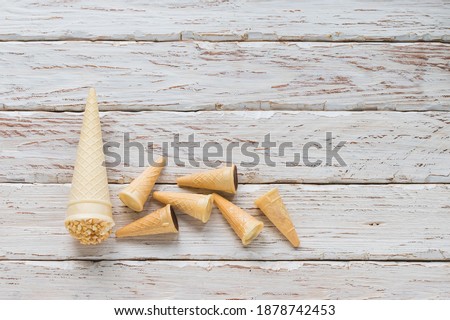 Sweet cake in the form of a cone cup on a white decorative background of planks