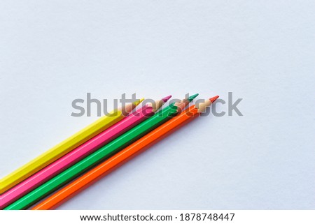 Coloring wooden pencil isolated on white background. Space for text. Colored pencils standing next to each other. Colored paints for drawing pictures. Top view.
