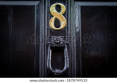 Large and bold 8 on a black wooden front door