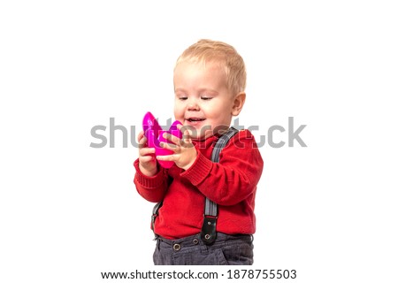 Boy in red jacket holds pink heart