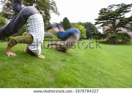 Motion blur of a young boy and a girl rolling down a hill slope. Royalty-Free Stock Photo #1878784327